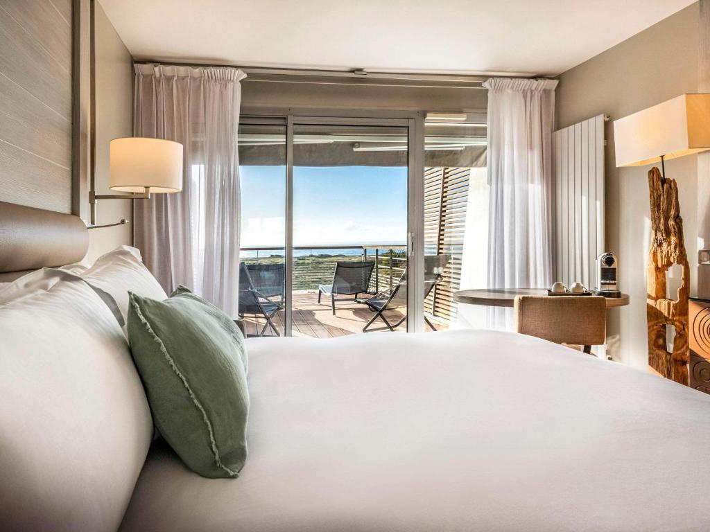 a bedroom with a bed and a view of the ocean at Sofitel Quiberon Thalassa sea & spa in Quiberon