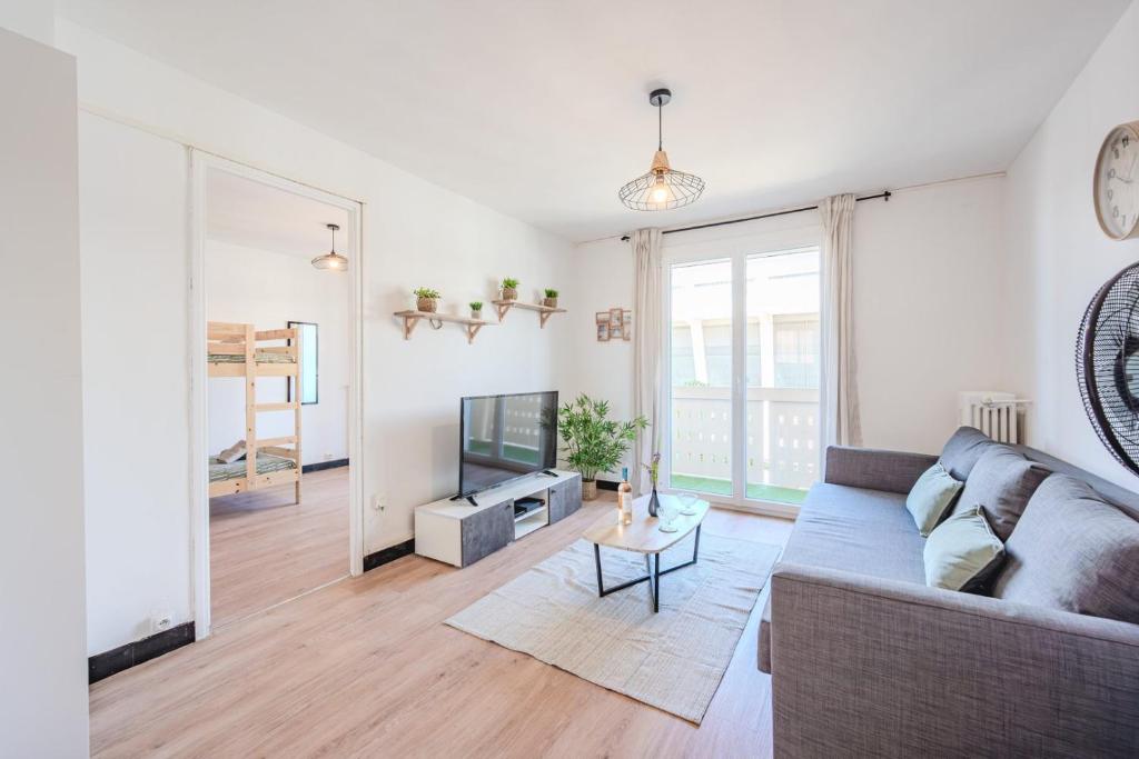 un salon avec un canapé et une télévision dans l'établissement Le Balcon de Mayol -Appartement T3, à Toulon