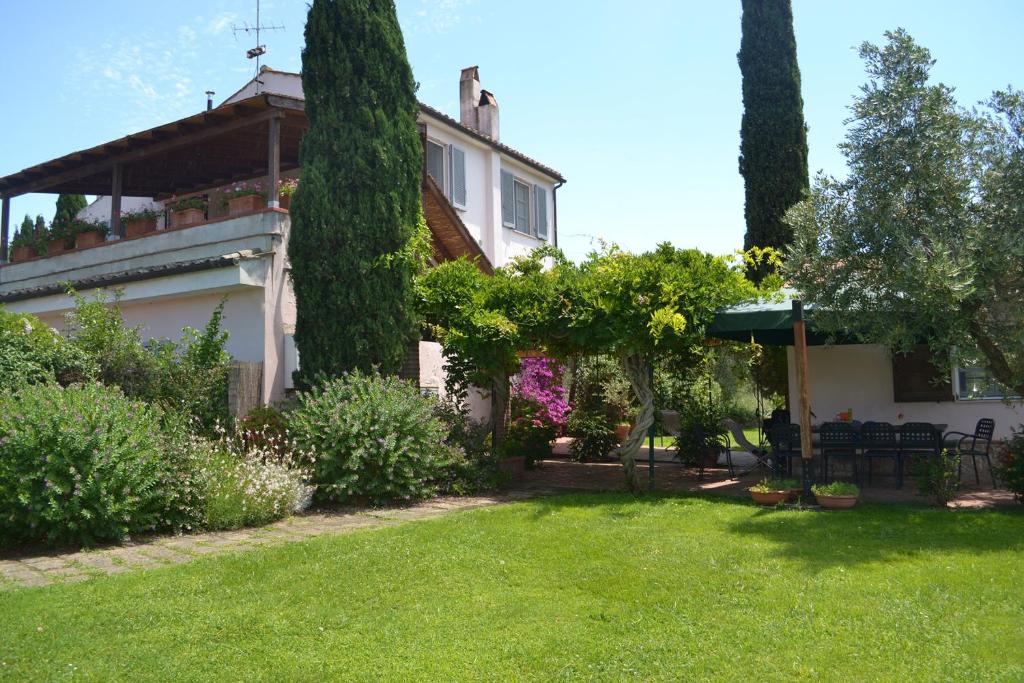 dom z ogródkiem z trawą i drzewami w obiekcie Casale Ai Poggi w mieście Orbetello