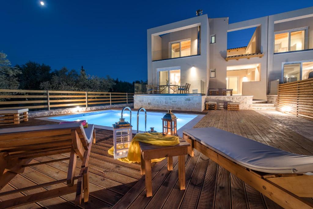 a backyard with a swimming pool and a house at Dolce Luxury Villas in Psarou