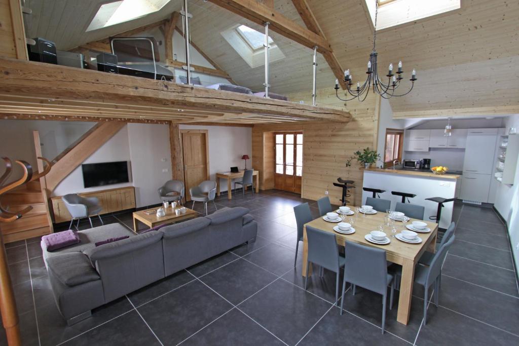 a large living room with a table and a kitchen at Entre Lac et Montagnes in Faverges