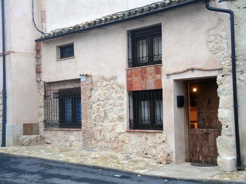 un edificio con puerta y ventanas en una calle en Casa Rural Alamar, en Tiedra