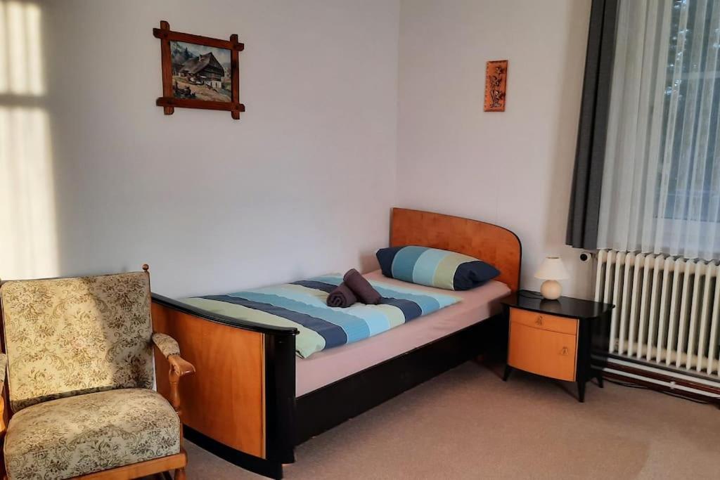 Cama pequeña en habitación con silla y silla en Ferienwohnung am Wildgehege bei Walsrode, en Walsrode