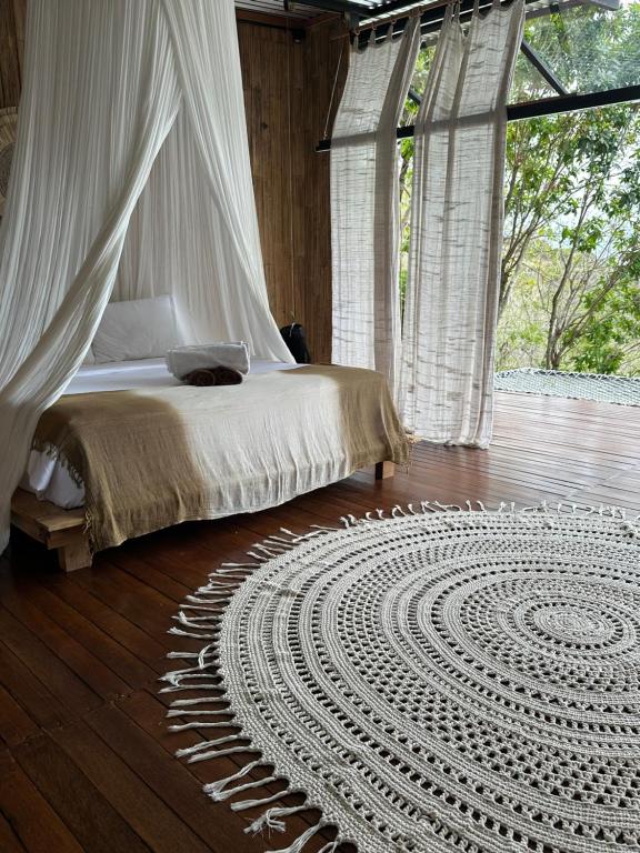 una camera con un letto e un tappeto su un pavimento in legno di SPICE TRADER a Nusa Penida