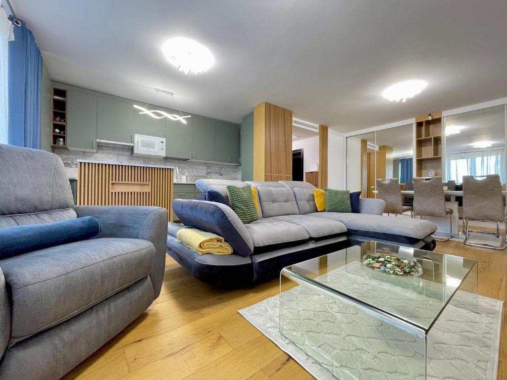 a living room with couches and a glass table at Apartment No 506 Lebada Lake in Pantelimon