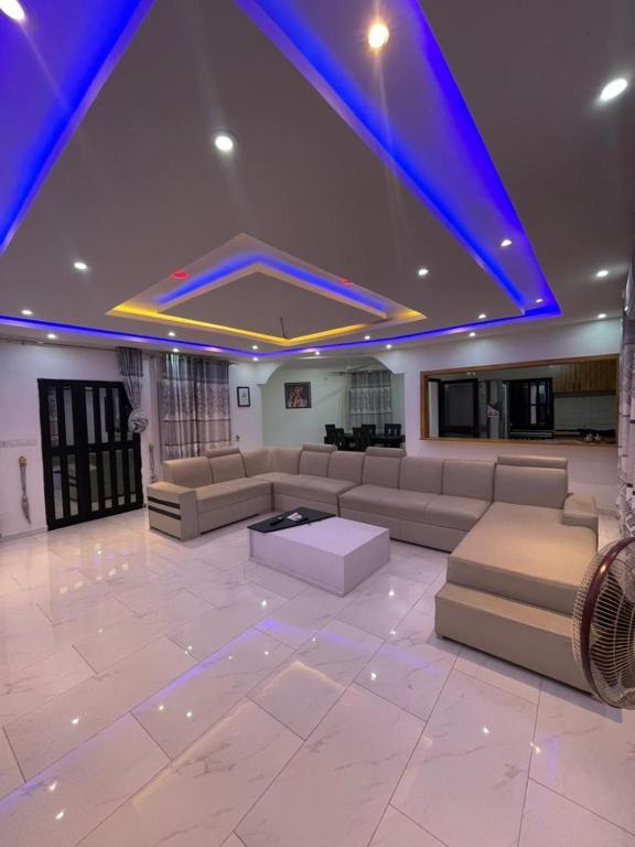 a large living room with couches and a blue ceiling at Tkj in Adidomé
