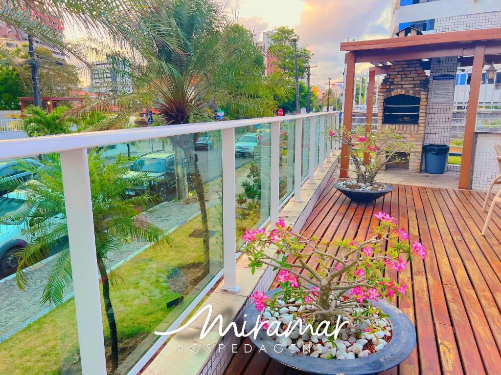 a balcony with two potted plants and flowers on it at Le Parc - Manaíra in Tambaú