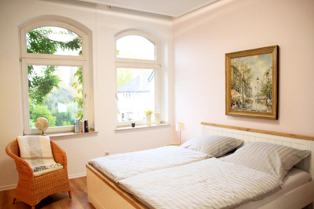 a bedroom with a bed and two windows at Villa Kolck in Xanten