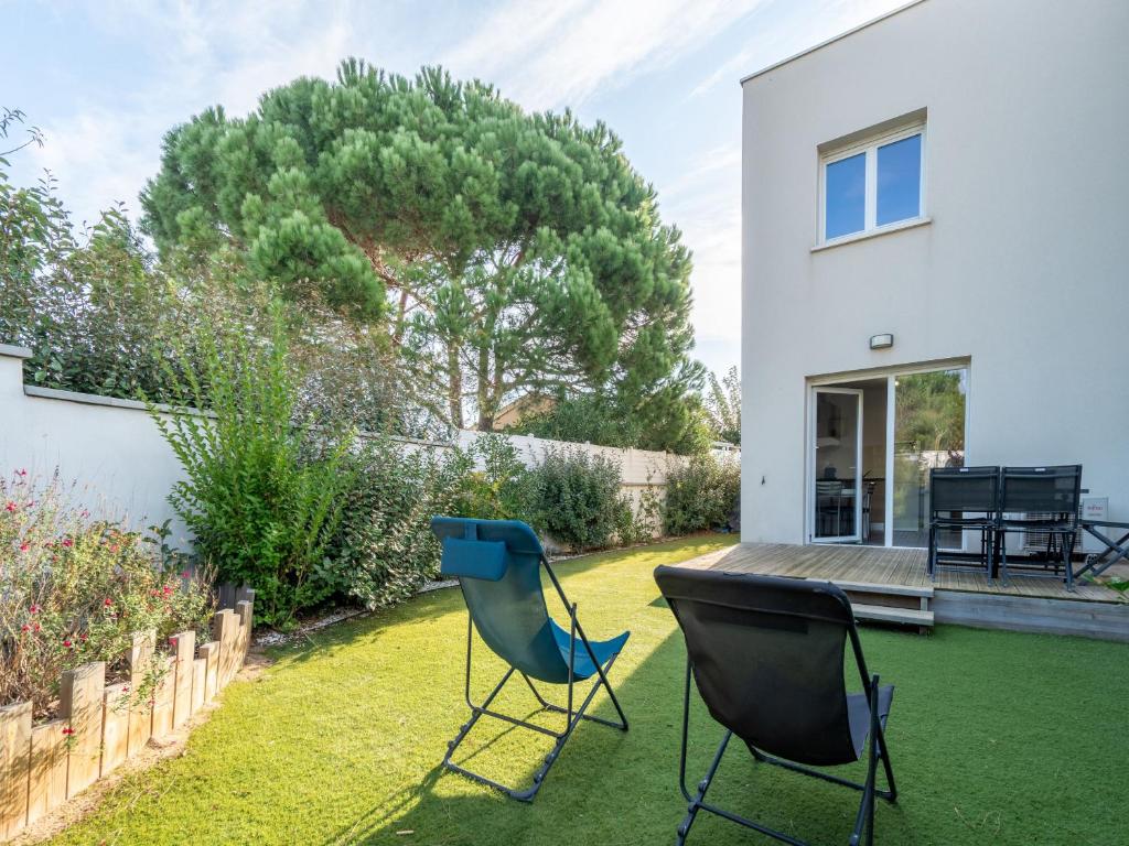 - un jardin avec deux chaises dans la cour d'une maison dans l'établissement LA DUNE N 33 - Villa 2P4, à Valras-Plage