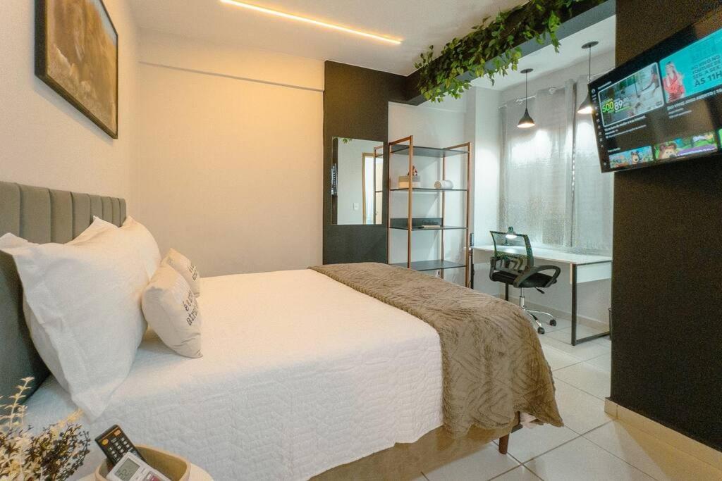 a bedroom with a bed with a television and a desk at Lindo e Confortável Espaço - MEL509 in Maringá
