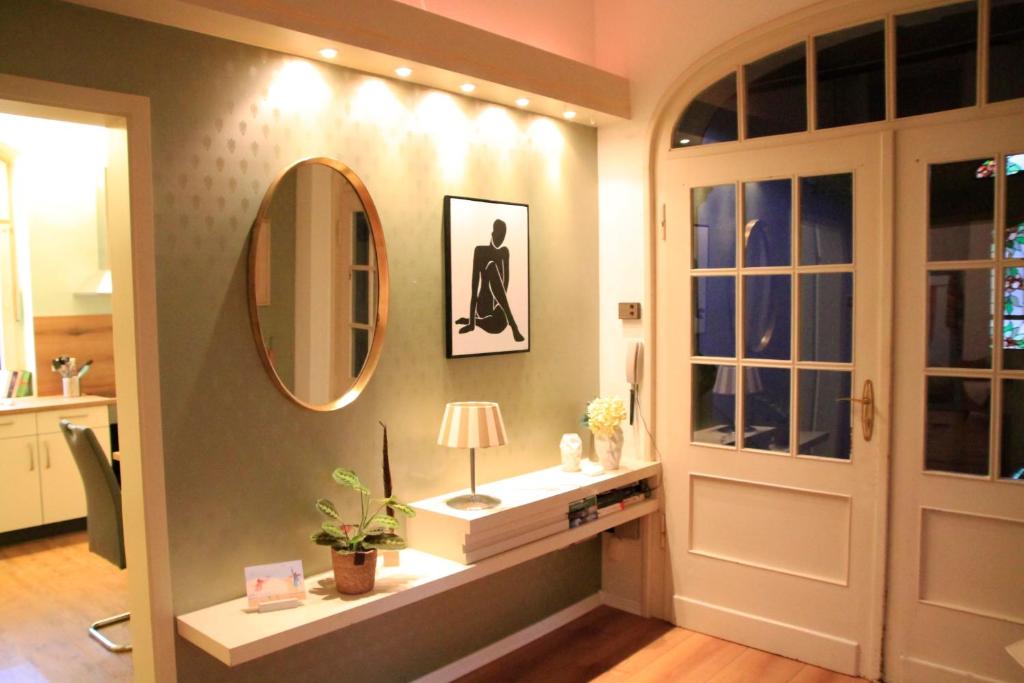 a hallway with a mirror and a table with a lamp at Villa Kolck in Xanten
