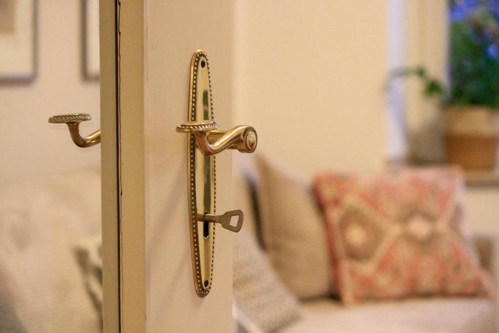 a gold door handle on a door with a couch at Villa Kolck in Xanten