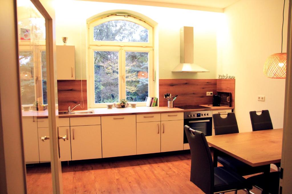 a kitchen with a table and a sink and a window at Villa Kolck in Xanten