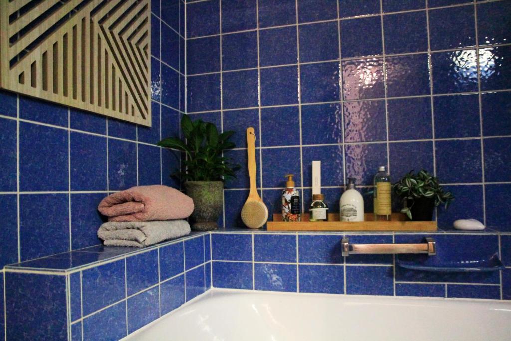 a blue tiled bathroom with a bath tub at Villa Kolck in Xanten