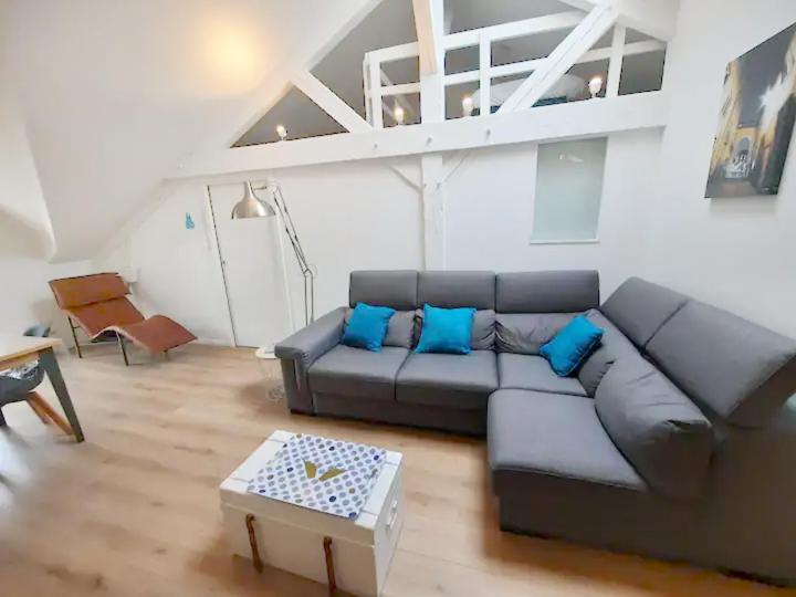 - un salon avec un canapé gris et des oreillers bleus dans l'établissement Legrand - 90m2, 6 Prs, 3 Ch, Proche Gare, à Dijon