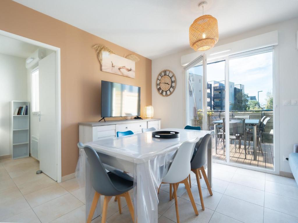une salle à manger avec une table et des chaises blanches dans l'établissement LA DUNE 77 - Villa 3P8, à Valras-Plage