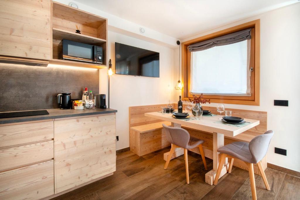 a kitchen with a table and chairs in a tiny house at BORMIO N'JOY in Bormio
