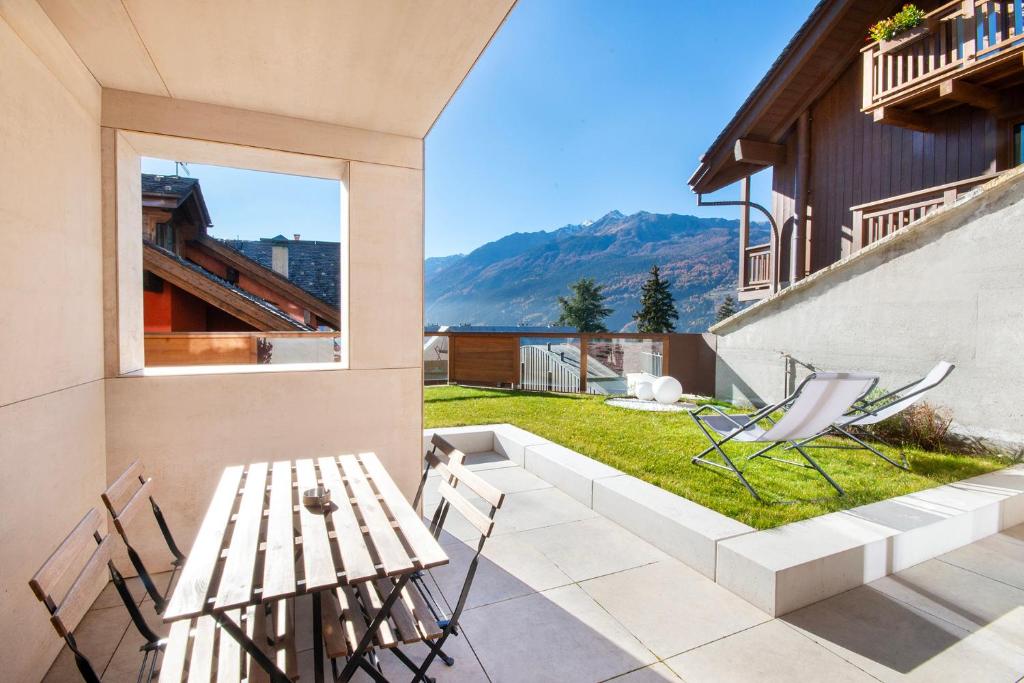 a patio with two chairs and a table and a window at BORMIO N'JOY in Bormio