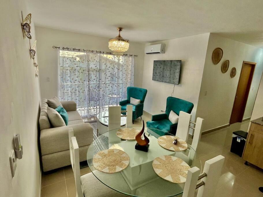 プンタ・カナにあるAmazing and cozy apt located in downtown of Punta Canaのガラスのテーブルと椅子のあるリビングルーム