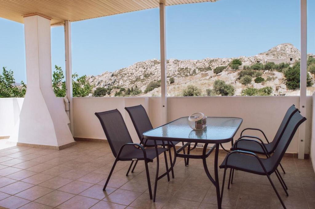 a table and chairs on a balcony with a mountain at Tsikalario Holiday House in Tsikkalarión
