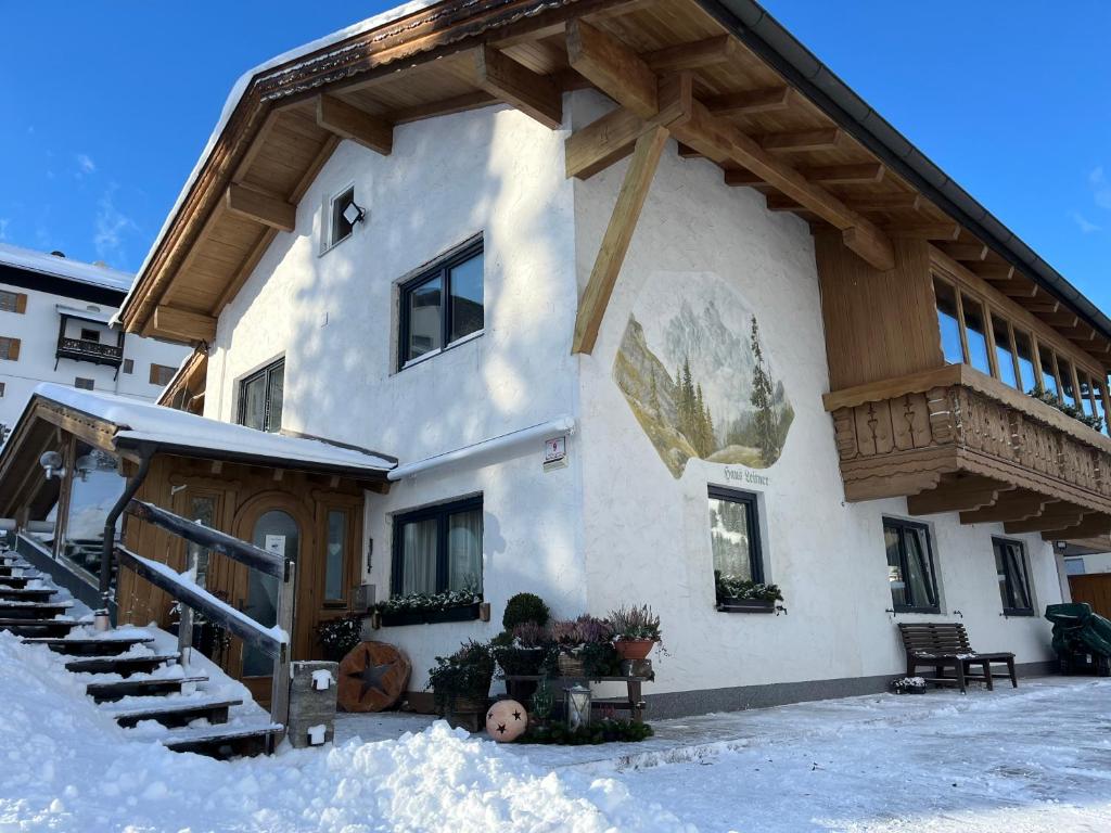 a house with snow on the ground in front of it at Apart Leitner in Lermoos