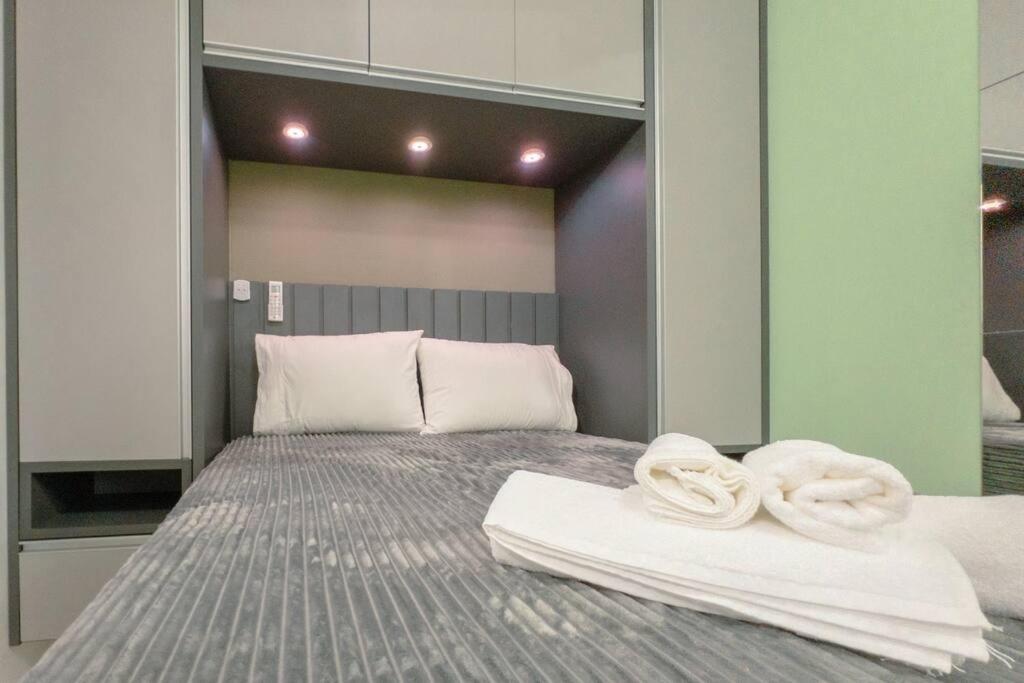 a bedroom with a bed with towels on it at Lar Estilo e Conforto - RJ2-19 in Maringá