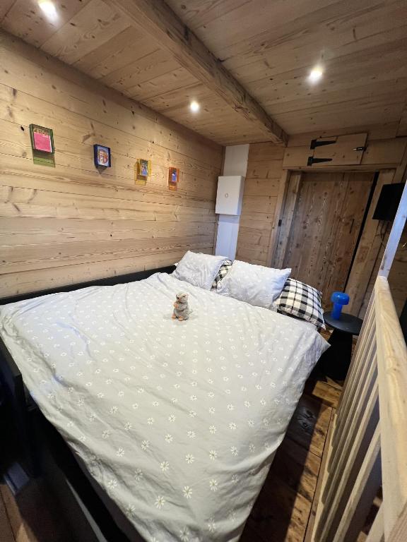 un grand lit dans une chambre aux murs en bois dans l'établissement Mazot du Criou - Samoëns, à Samoëns