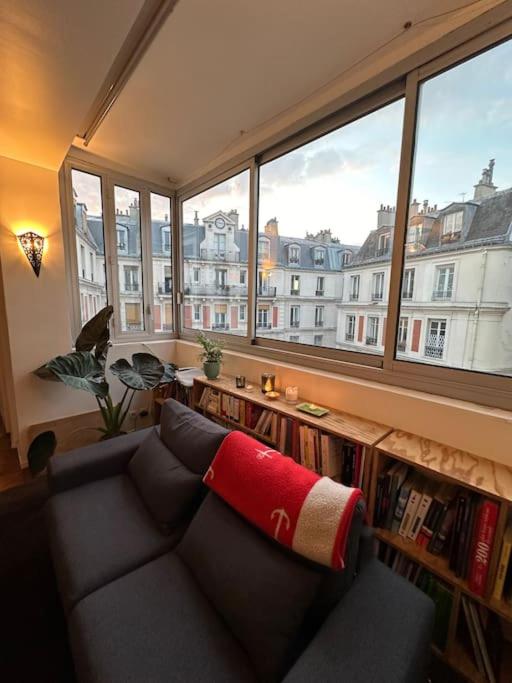 un salon avec un canapé et une grande fenêtre dans l'établissement Grand loft Montmartre, à Paris