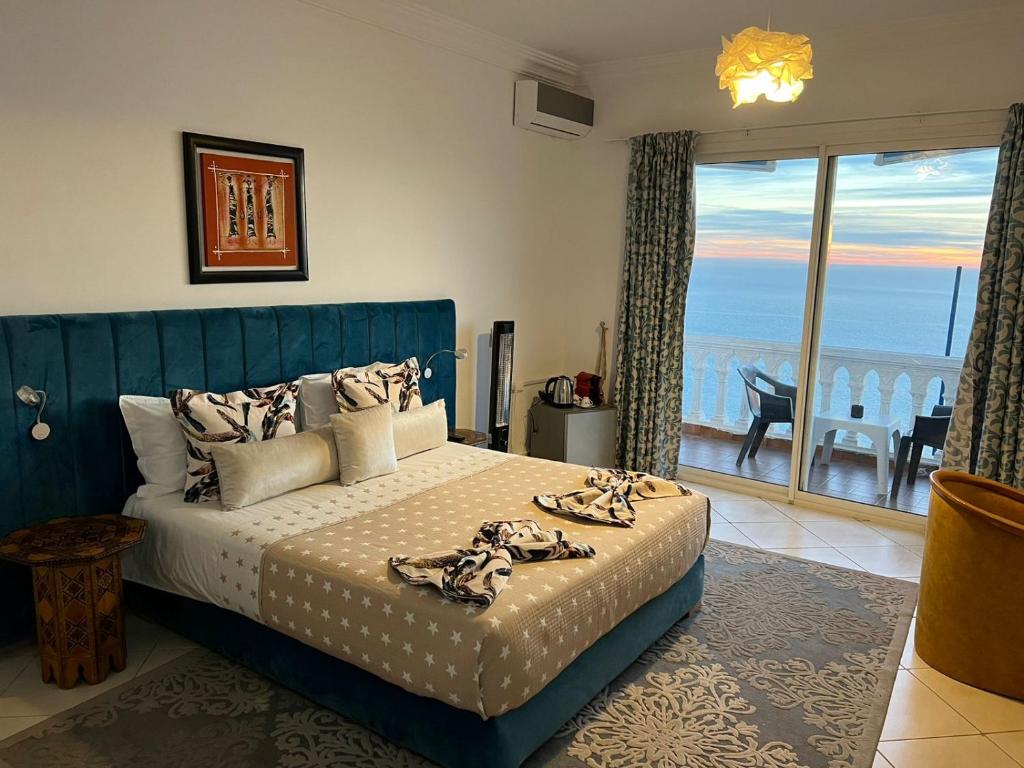 a bedroom with a bed with a view of the ocean at Riad Ras Lafaa in Safi