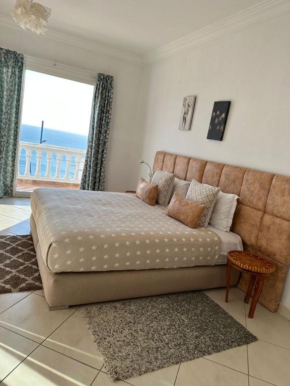 a bedroom with a large bed with a view of the ocean at Riad Ras Lafaa in Safi