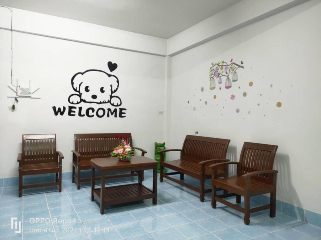 a waiting room with benches and a welcome sign on the wall at Sawasdee Home in Betong