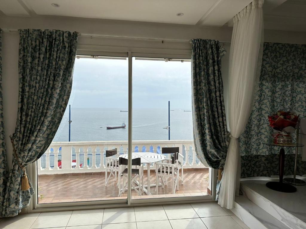a room with a balcony with a view of the ocean at Riad Ras Lafaa in Safi