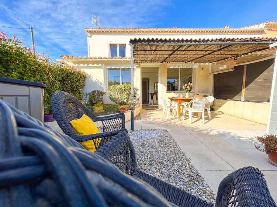 un patio avec des chaises et une table avec un coussin jaune dans l'établissement Jardin - Parking - 10 min Centre Ville, à Sanary-sur-Mer