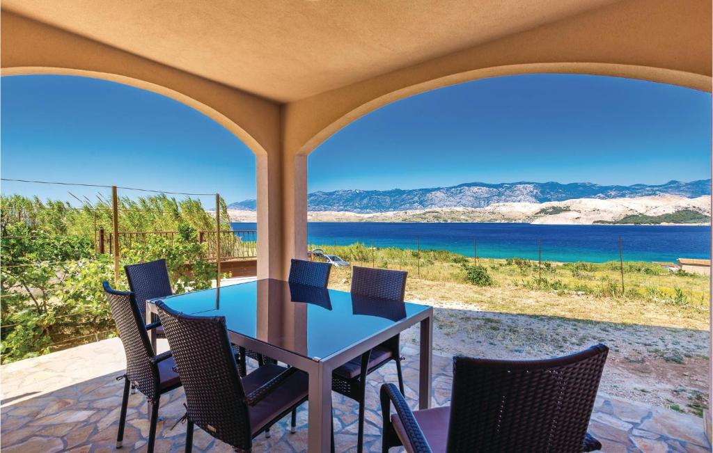 stół i krzesła na tarasie z widokiem na ocean w obiekcie Holiday Home Pag 5 w mieście Pag