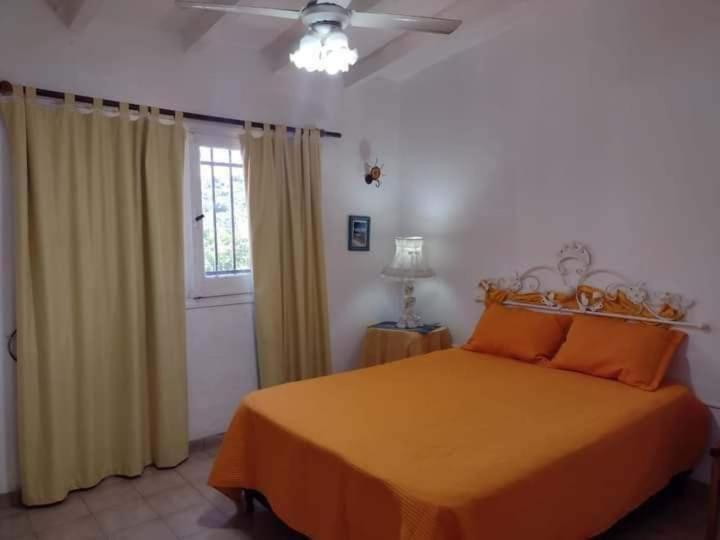 a bedroom with a bed and a ceiling fan at Casa y cabaña de Gachy in Villa Carlos Paz