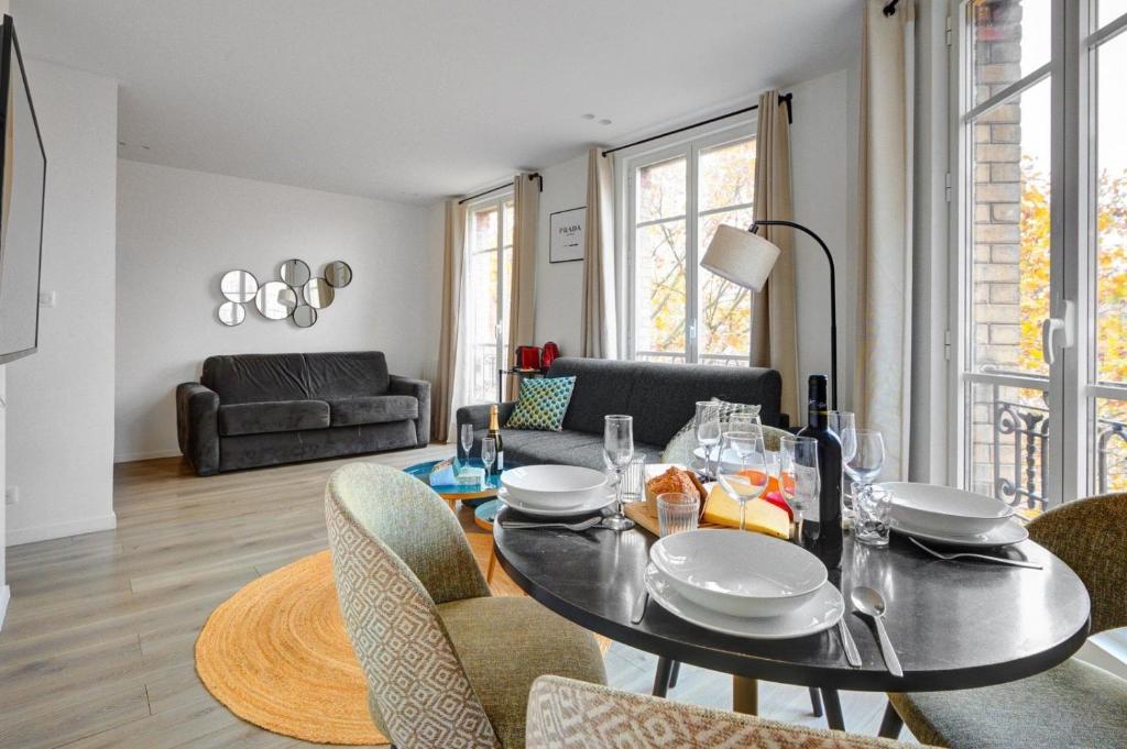 - un salon avec une table à manger et des chaises dans l'établissement 153 Suite Mylene - Superbe Appartement à Paris, à Paris