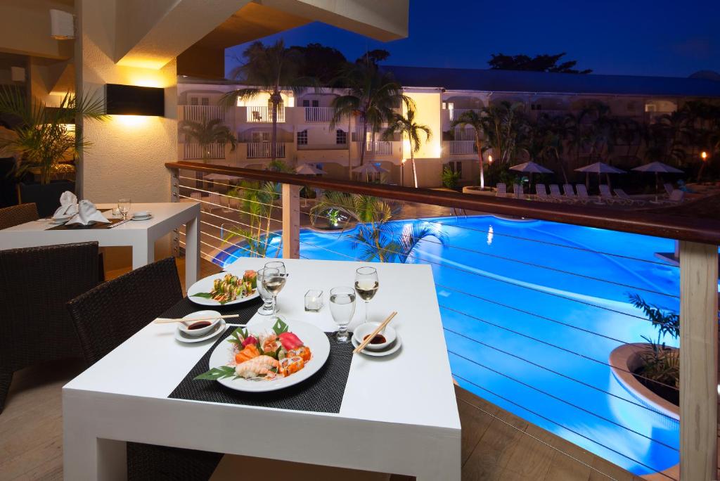 a table with two plates of food on a balcony at Sugar Bay Barbados - All Inclusive in Bridgetown