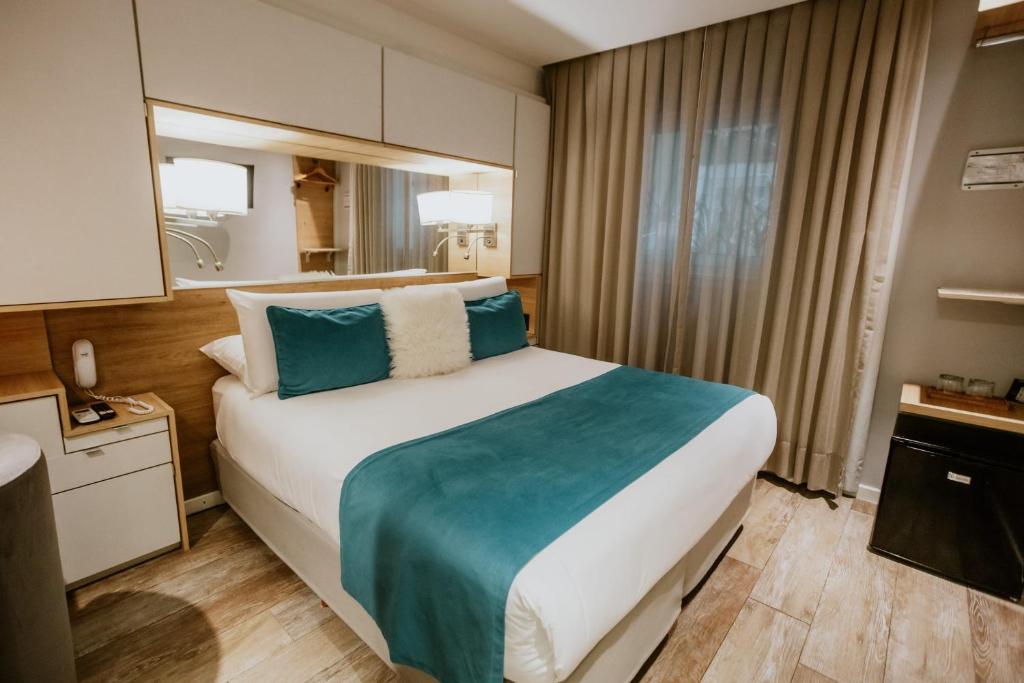 a hotel room with a large bed and a mirror at Hotel Club del Golf in Mar del Plata