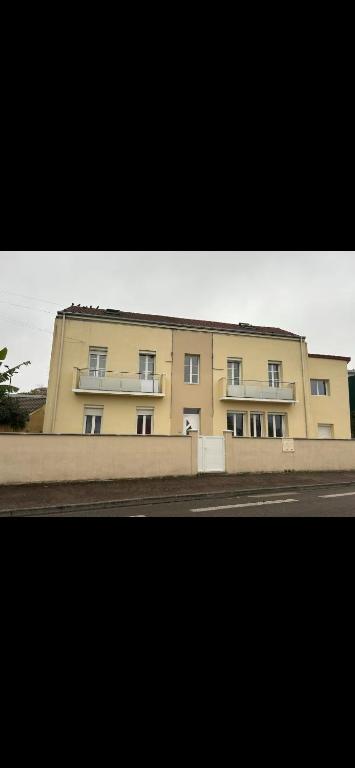 un grand bâtiment jaune sur le côté d'une rue dans l'établissement L'Immeuble de l'Avenue, à Chalon-sur-Saône