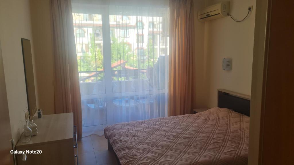 スヴェティ・ヴラスにあるParadise dreams family apartamentsのベッドと大きな窓のある寝室