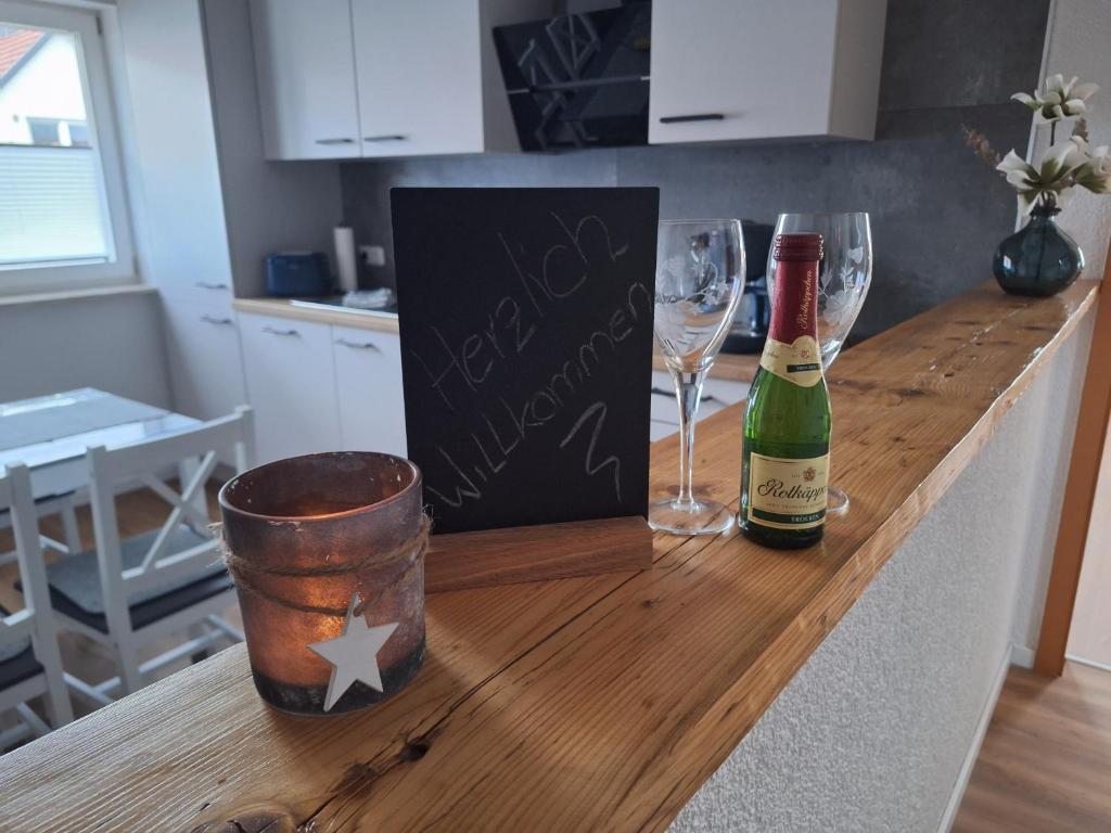 a counter with two glasses and a bottle of wine at Appartement Wasserburg in Andisleben