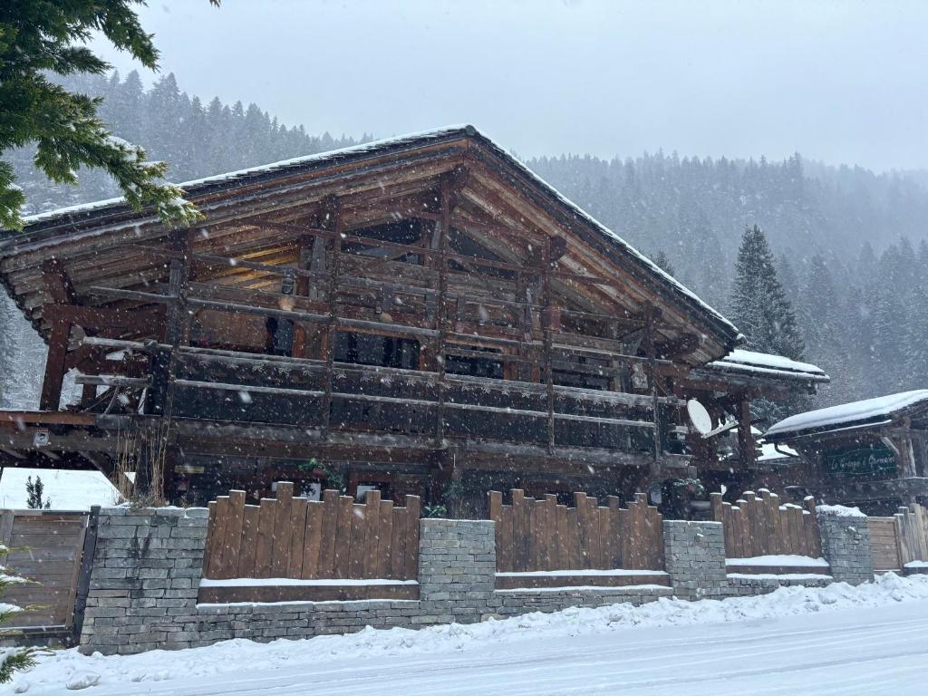 d'un grand bâtiment en bois recouvert de neige. dans l'établissement Chalet La Grange à Germaine - Propriétés Mont Amour, à Avoriaz