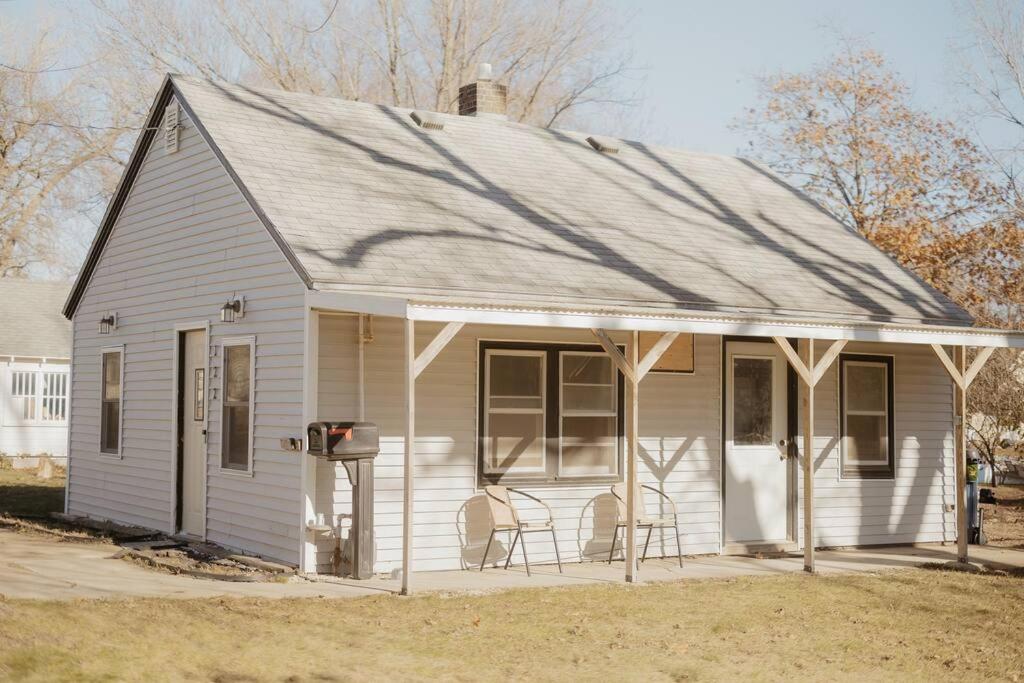 a small white house with chairs on the porch at Walk to Cafe & Mall, One Mile to Dordt, Dog Theme in Sioux Center