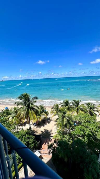 a view of a beach with palm trees and the ocean at The Happy Place in San Juan