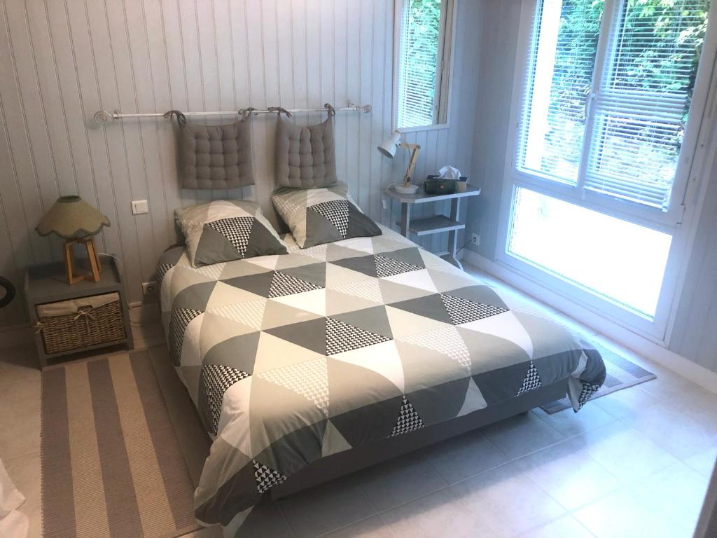 une chambre avec un lit avec une couette noire et blanche dans l'établissement Le Petit Pez, à Saint-Nazaire