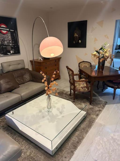 - un salon avec une table en verre et un vase dans l'établissement Charmant, appartement, parking gratuit, à Colmar