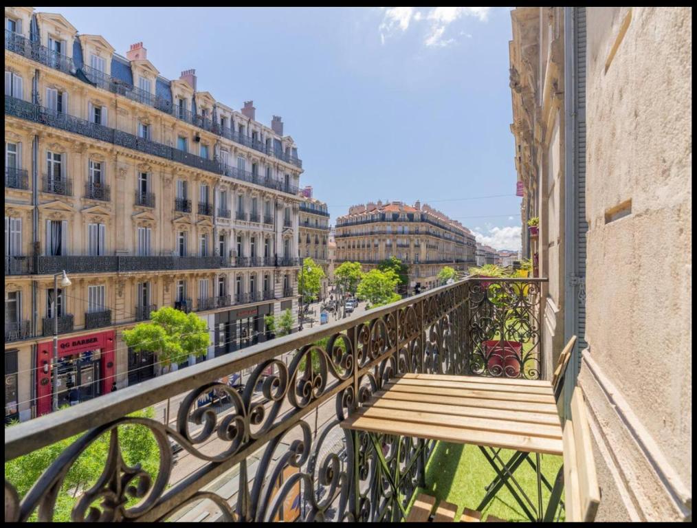 - un balcon avec un banc en bois dans l'établissement Appart sur la rue de la république, à Marseille