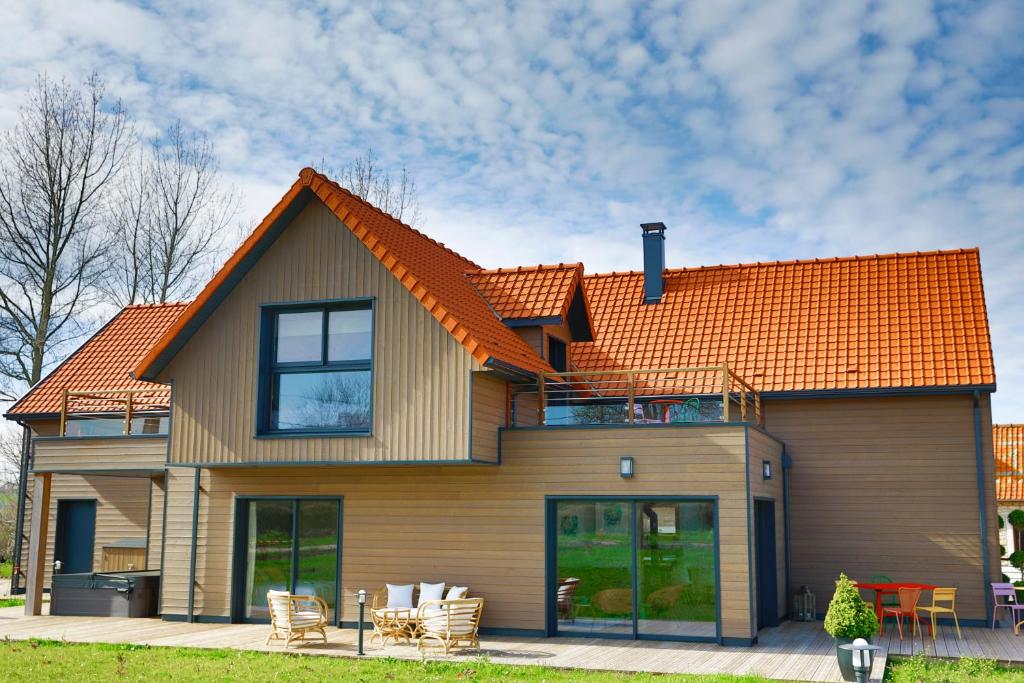a house with an orange roof and some chairs at Chez Watersy in Belle-et-Houllefort