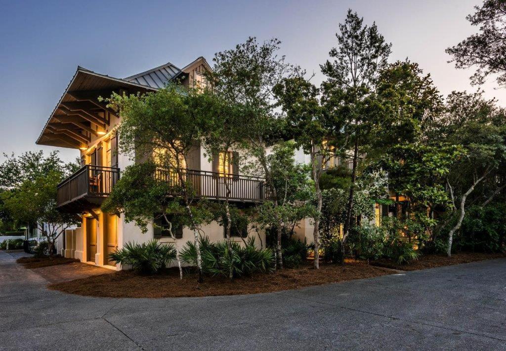 a large house with trees in front of it at Belize Carriage House in Rosemary Beach