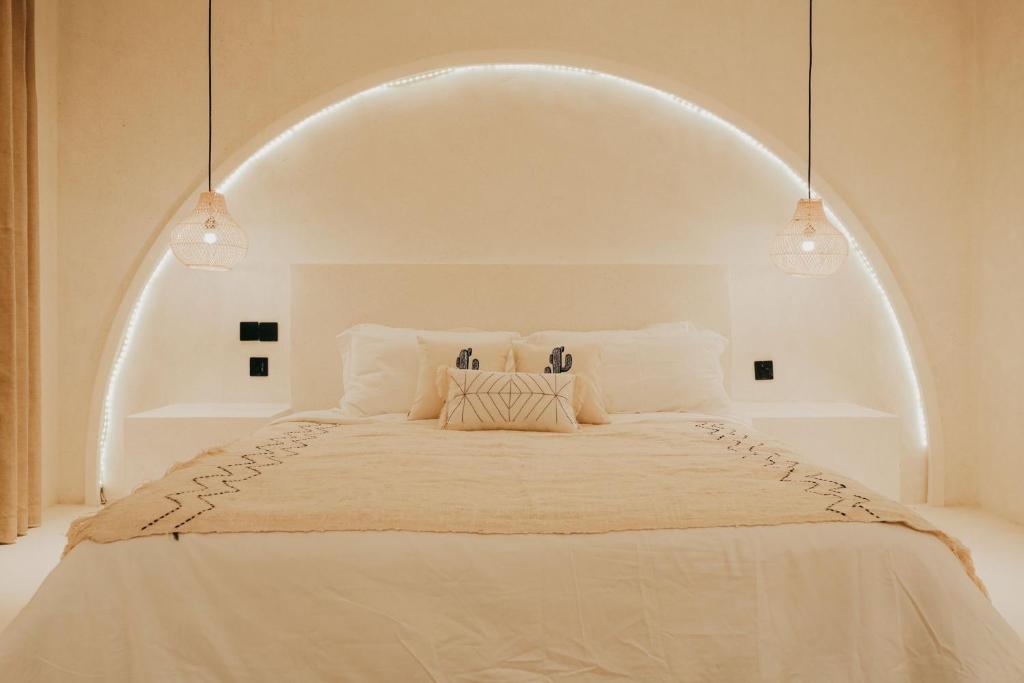 a bedroom with a large white bed with an archway at Inlander Villas A- Private pool luxury Villa in Gili Trawangan